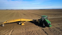 an aerial view of a tractor plowing a field