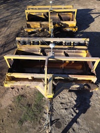 an aerial view of a yellow machine in the dirt