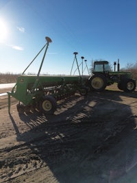 a green tractor parked on a dirt road