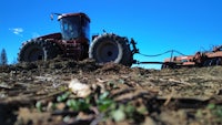 a tractor plows a field of dirt