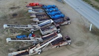 an aerial view of a group of trucks parked on a dirt road